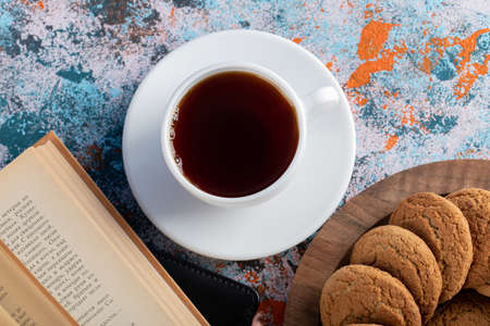 Cookies on a wooden platter served with a cup of tea