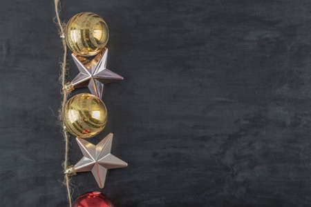 Colorful ornaments hanged from the rustic thread on the dark stone backgroundの写真素材