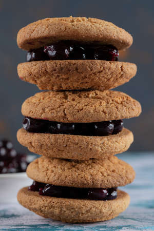 Crispy oatmeal cookies with blackcurrant berry confiture on itの写真素材