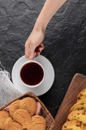 Cookies on a wooden platter served with a cup of tea