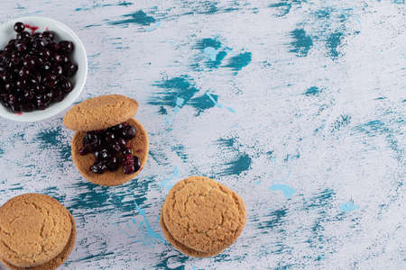 Crispy oatmeal cookies with blackcurrant berry confiture on itの写真素材
