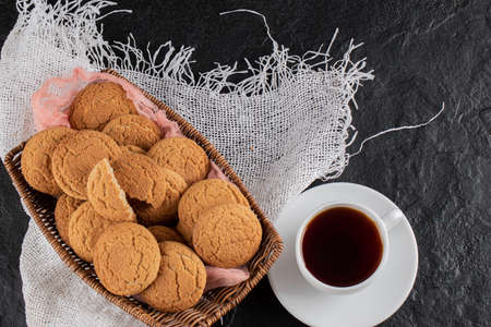 Cookies on a wooden platter served with a cup of tea
