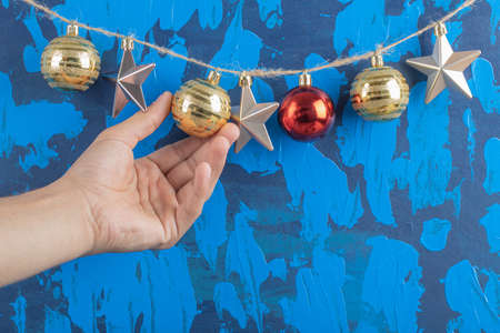 Colorful ornaments hanged from the rustic thread on blue textured background