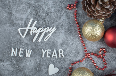 Happy new year writing with christmas cones and balls around on backgroundの写真素材