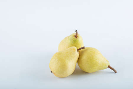 Three ripe pears on a white background