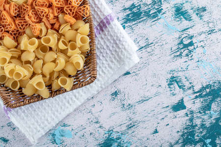 Assortment of raw pasta in wooden basketの写真素材