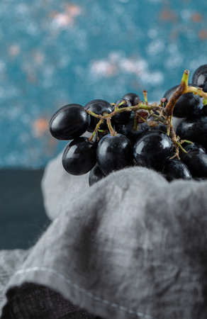 Dark fresh grape in basket on a colorful backgroundの写真素材