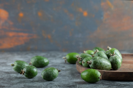 A wooden cutting board with fresh feijoaの写真素材