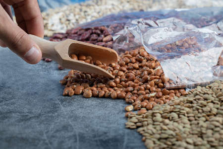 Female hand taking red beans from marble backgroundの写真素材