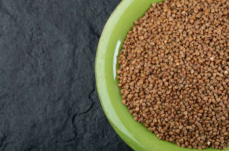 Bunch of raw buckwheat in green bowlの写真素材