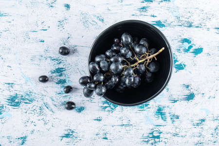 Dark fresh grape in bowl on a colorful backgroundの写真素材