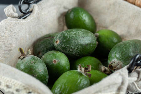 Bunch of feijoa fruits in wooden basketの写真素材