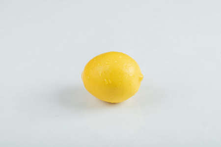 A whole fresh lemon on a white backgroundの写真素材