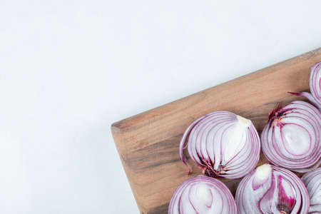 Slices of onion on a wooden cutting boardの写真素材