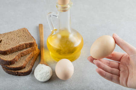 Female hands holding a fresh chicken egg