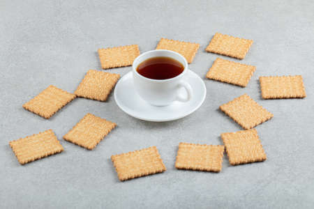 A cup of aroma tea with crackers on a gray backgroundの写真素材
