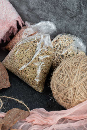 Many of wrapping uncooked beans on a gray background