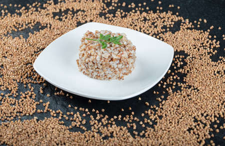 Delicious buckwheat with greens on a white plate