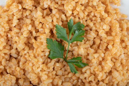 Delicious bulgur with greens on a green plateの写真素材