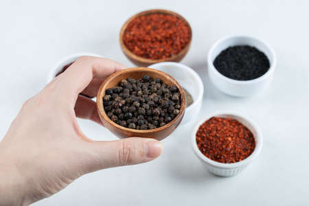 Hand holding a clay bowl full of dried pepperの写真素材