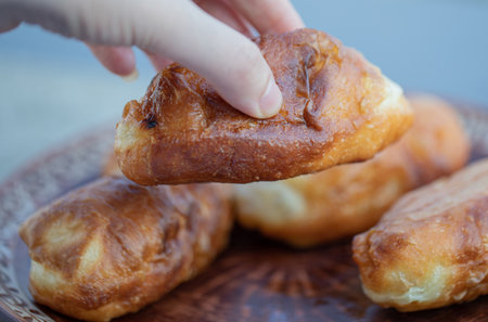 Hand taking a fresh delicious homemade pastry on a brown plateの写真素材