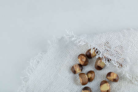 Bunch of roasted chestnuts on white cloth
