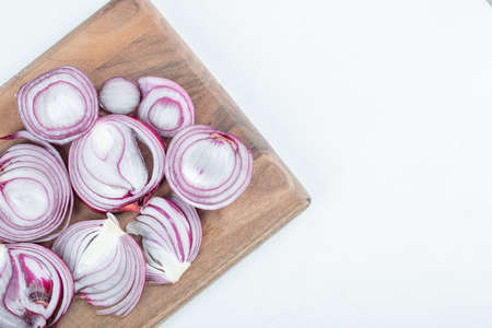 Slices of purple onion on wooden boardの写真素材