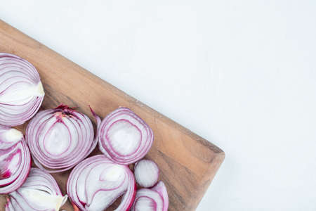 Slices of onion on a wooden cutting boardの写真素材