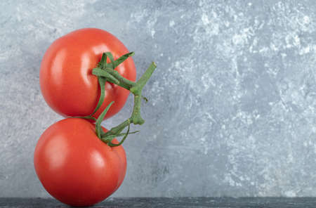 Two whole fresh juicy tomatoes on a gray backgroundの写真素材