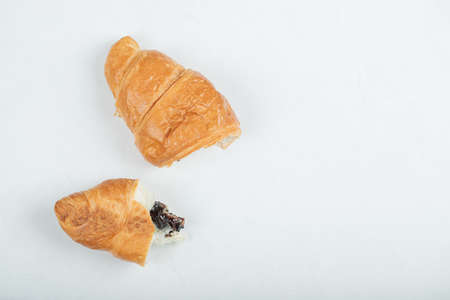 One whole fresh delicious croissant on a white backgroundの写真素材
