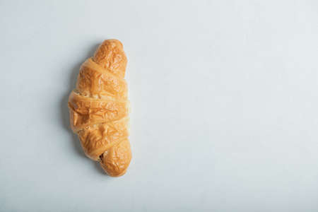 One whole fresh delicious croissant on a white backgroundの写真素材