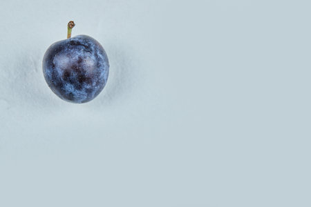 Fresh plum isolated on a blue backgroundの写真素材