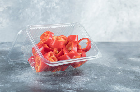 Slices of sweet red peppers on a plastic plateの写真素材
