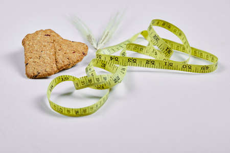 Biscuits and tape measure on a white background