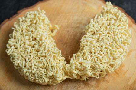 Uncooked fresh noodles on a wooden tableの写真素材