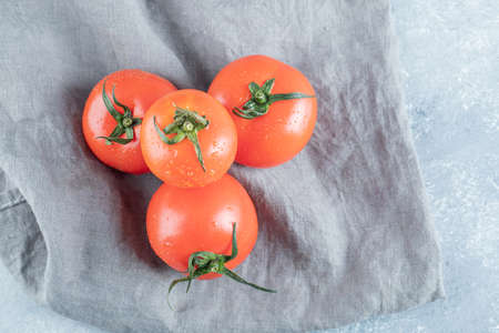 Some of fresh tomatoes on a gray tableclothの写真素材
