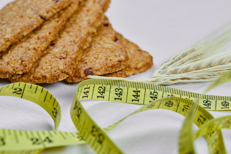 Biscuits and tape measure on a white background