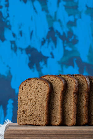 A wooden cutting board with slices of brown bread