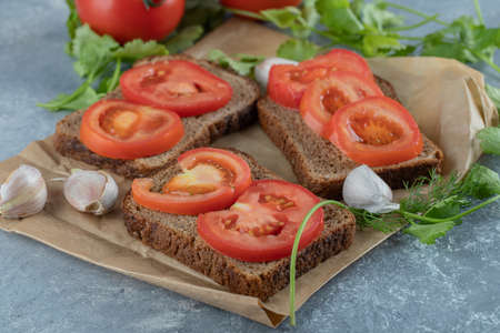 Delicious toasts with slices of tomato on a gray backgroundの写真素材