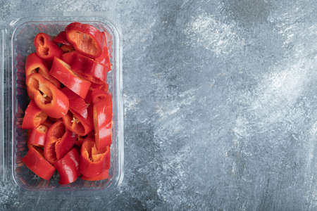 Slices of sweet red peppers on a plastic plate