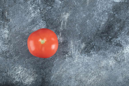 One fresh juicy tomato on a gray backgroundの写真素材