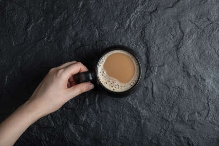 A black cup of coffee on a dark backgroundの写真素材