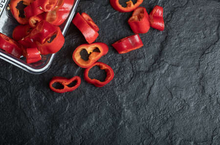 Slices of sweet red peppers on a dark backgroundの写真素材