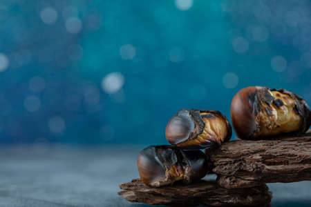 Delicious fried chestnuts on a tree barkの写真素材