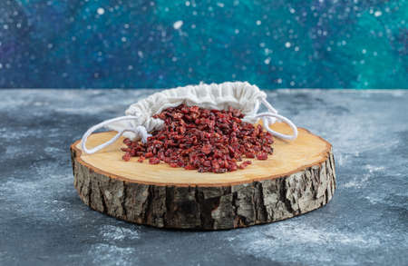 A wooden board full of dried cranberriesの写真素材