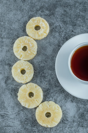 A cup of aroma tea with dried pineappleの写真素材