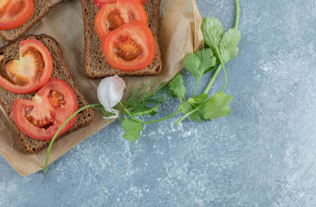 Delicious toasts with slices of tomato on a gray backgroundの写真素材