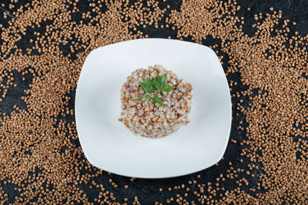 Delicious buckwheat with greens on a white plate