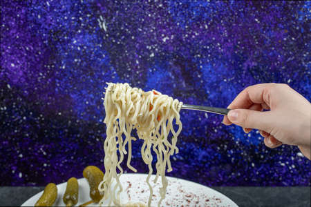 A white plate with delicious noodles and pickled gherkins