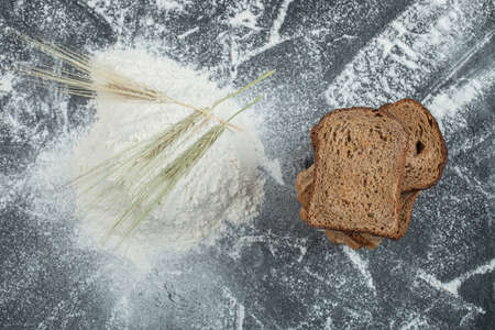 Slices of brown bread with flour on a colorful background